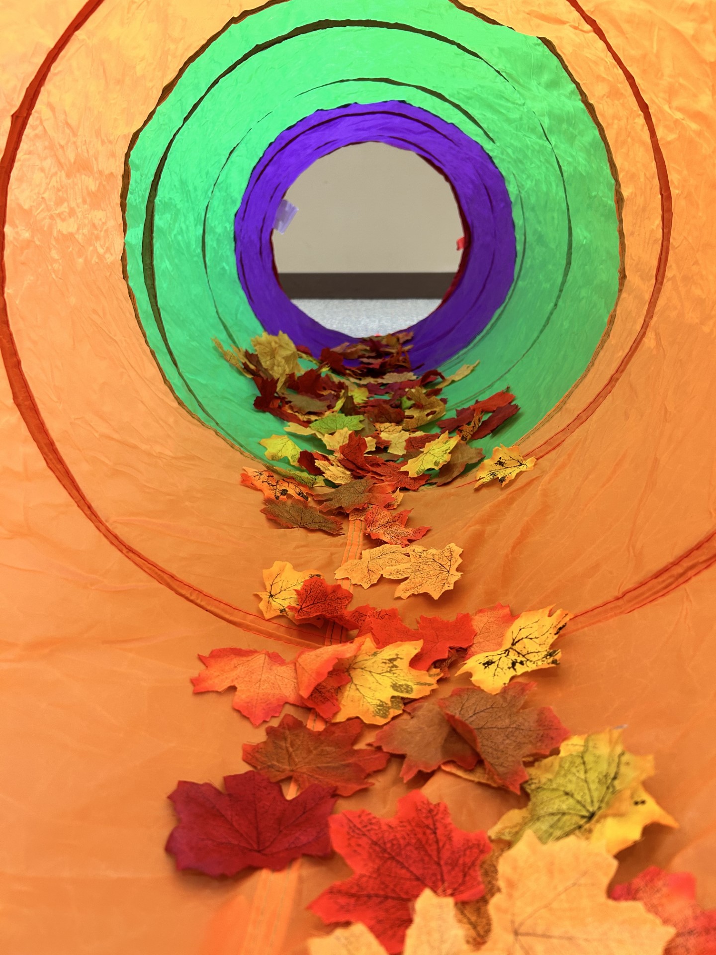 Play tunnel with leaves inside to crawl through