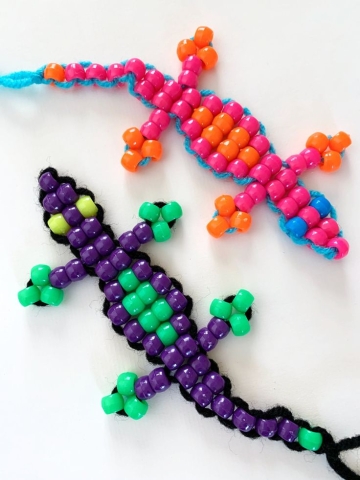 Two lizards made out of crafting chord and beads. 