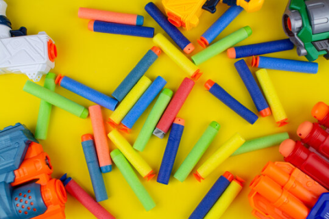 NERF darts in assorted colors on a yellow background