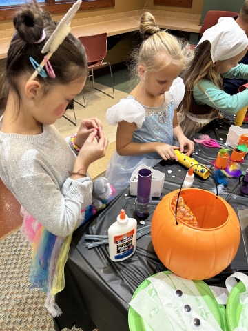 Kids dressed in costume making Halloween crafts