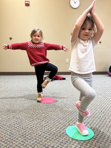 Two girls practicing tree yoga pose