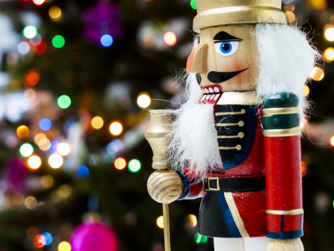 image of nutcracker with Christmas lights in background