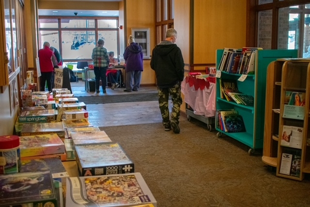 table and book carts filled with puzzles and books for sale